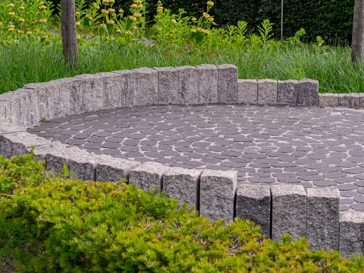 Newly installed paver patio bordering a landscaped backyard